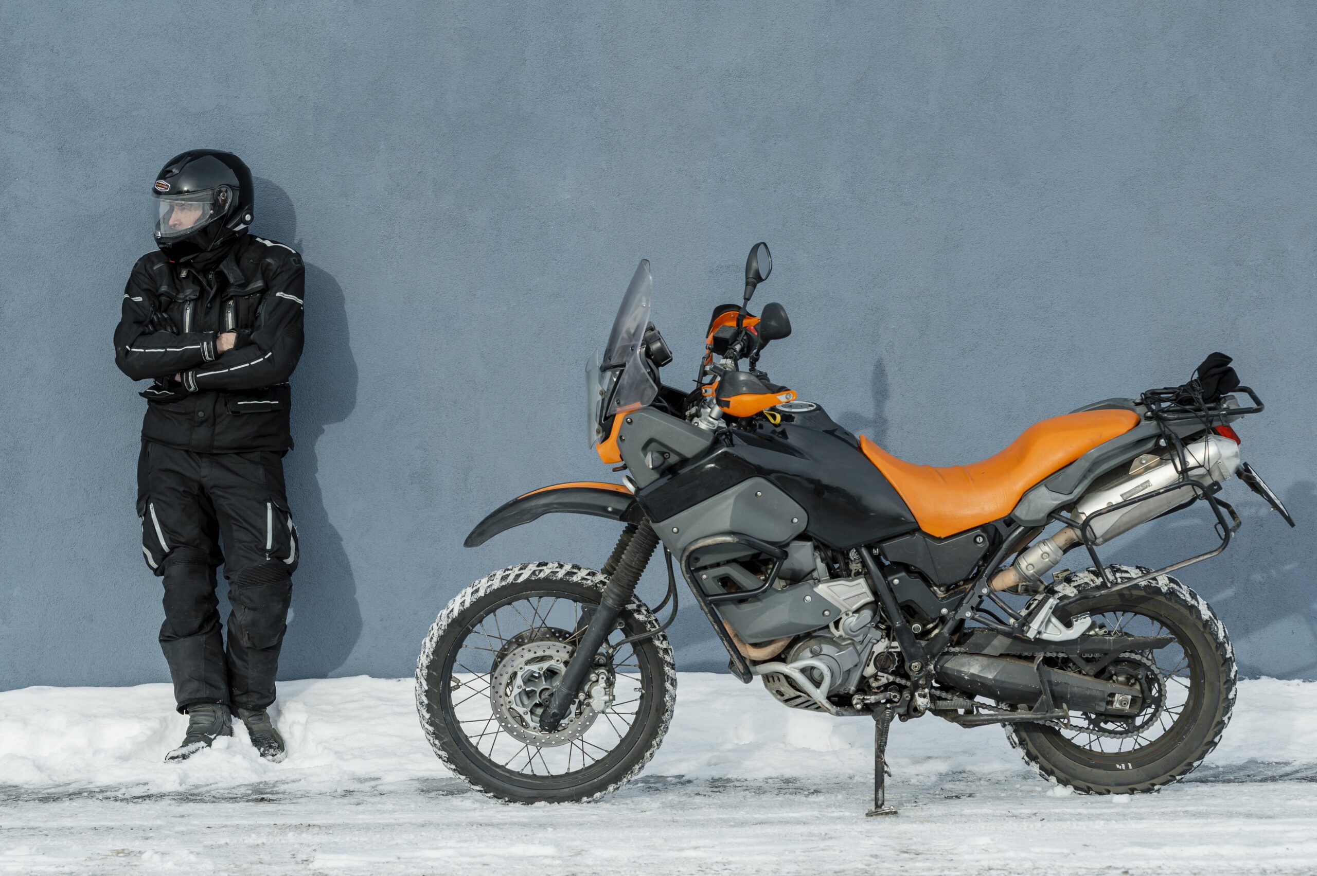 Rider with Himalayan bike standing in snow during winter trip